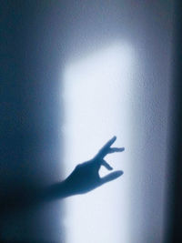 Shadow of person hand on wall