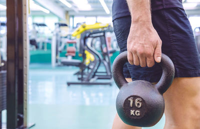 Midsection of man holding kettlebell