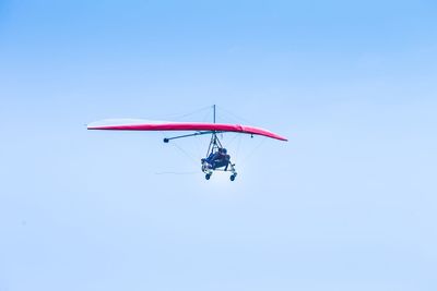 Low angle view of people hang gliding in sky