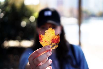 Close-up of woman holding maple leaf