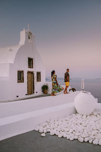 Full length of couple standing by church against sea