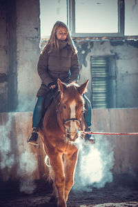 Woman with eyes closed riding horse