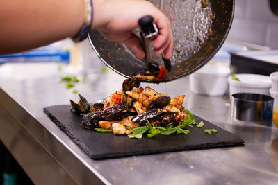 Cropped hand of person preparing food on table