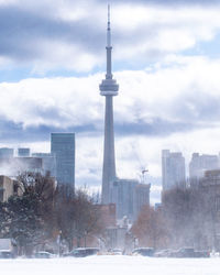 View of buildings in city against cloudy sky