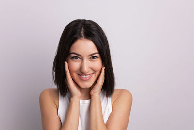 Portrait of young woman against white background