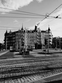 Railroad tracks in city against sky