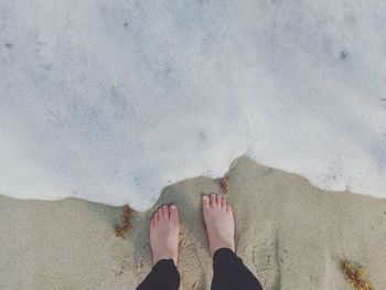 Low section of woman standing on beach