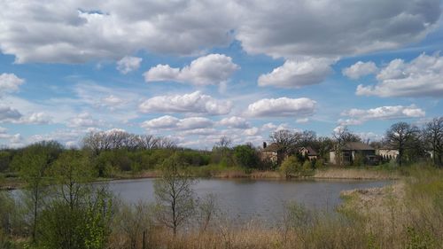 Built structure by river against cloudy sky