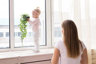 Side view of woman looking through window