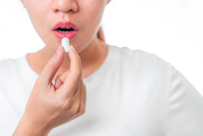 Close-up of woman holding hands over white background