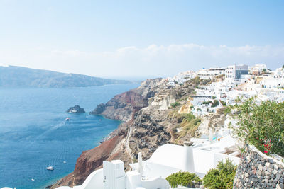 High angle view of city by sea against sky