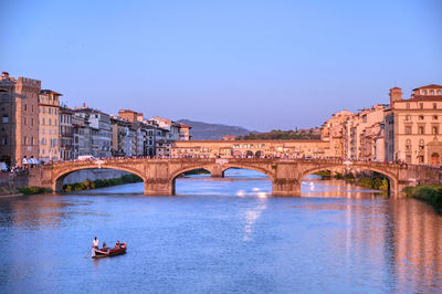 Arch bridge over river against blue sky