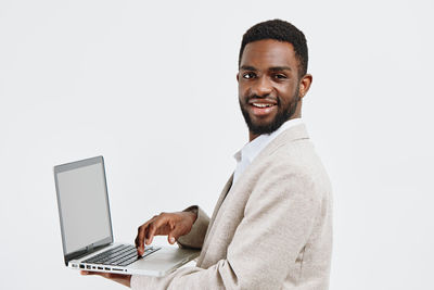 Portrait of young man standing against white background