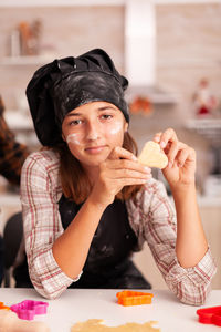 Portrait of cute girl holding cookie