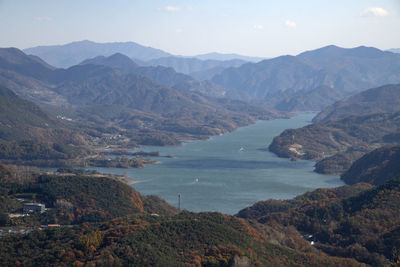 High angle view of lake and mountains against sky