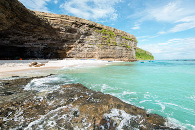 Scenic view of rock formation in sea against sky