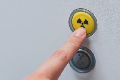 Close-up of hand pressing radioactive warning symbol button 