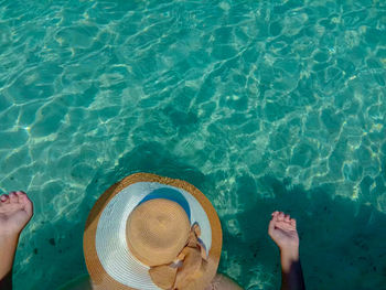 Low section of person wearing hat on swimming pool