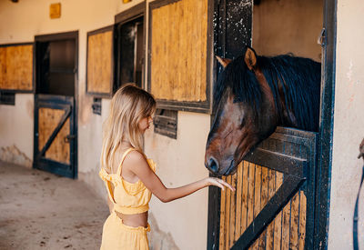 Side view of young woman with horse