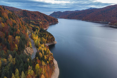 High angle view of lake by mountain against sky