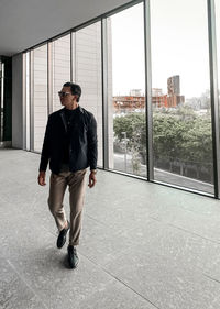 Full length of young man looking through window