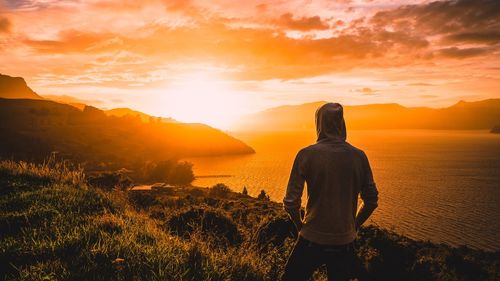 Rear view of man looking at sunset