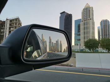 Reflection of buildings on side-view mirror