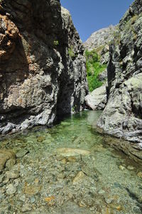 Rock formation amidst water against sky