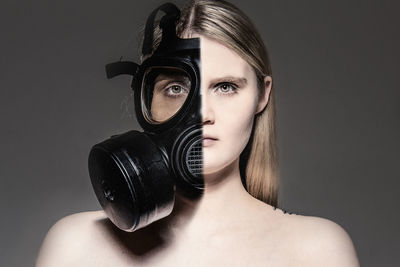 Portrait of young woman photographing against black background