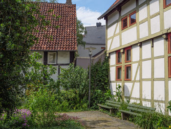 House by trees and building against sky