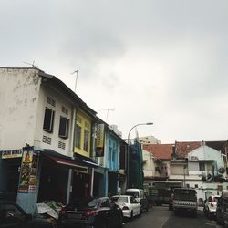 Cars on street in city against sky