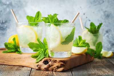 Two glass with lemonade or mojito cocktail with lemon and mint, cold refreshing drink.