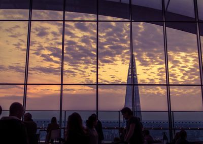 Silhouette of people on sea at sunset