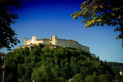 Low angle view of castle against clear blue sky