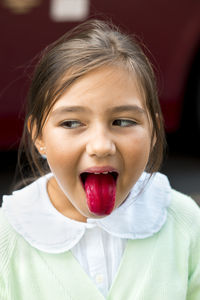 Girl showing red tongue after drinking strawberry granita