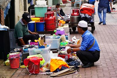 People sitting at market stall in city