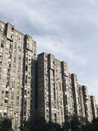 Low angle view of buildings against cloudy sky