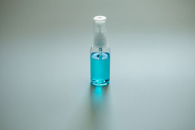 Close-up of blue bottle on table against white background