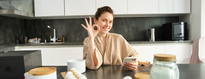 Portrait of young woman drinking coffee at home