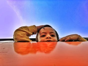 Portrait of boy looking at camera against sky