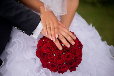 Midsection of women holding groom's hand