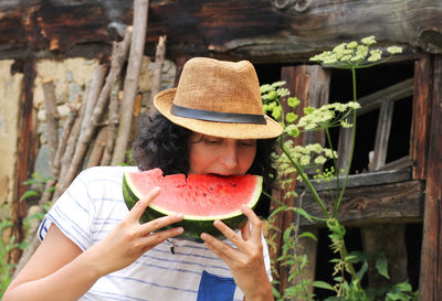 Midsection of woman wearing hat holding ice cream