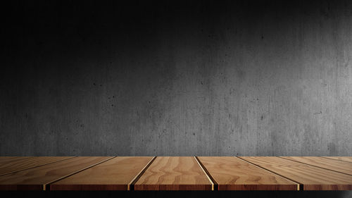 Empty wooden table against wall