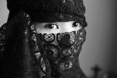 Close-up of young woman with face covered by black textile