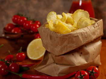 Close-up of potato chips with cherry tomatoes on table