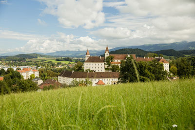 Buildings on field against sky