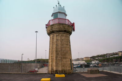 Tower by sea against sky