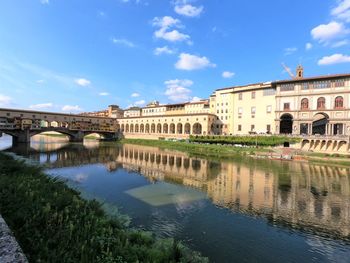 Arch bridge over river against buildings