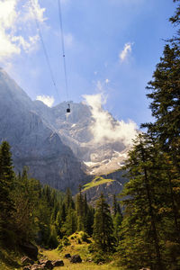 Low angle view of overhead cable car against sky