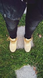 Low section of man standing on grassy field